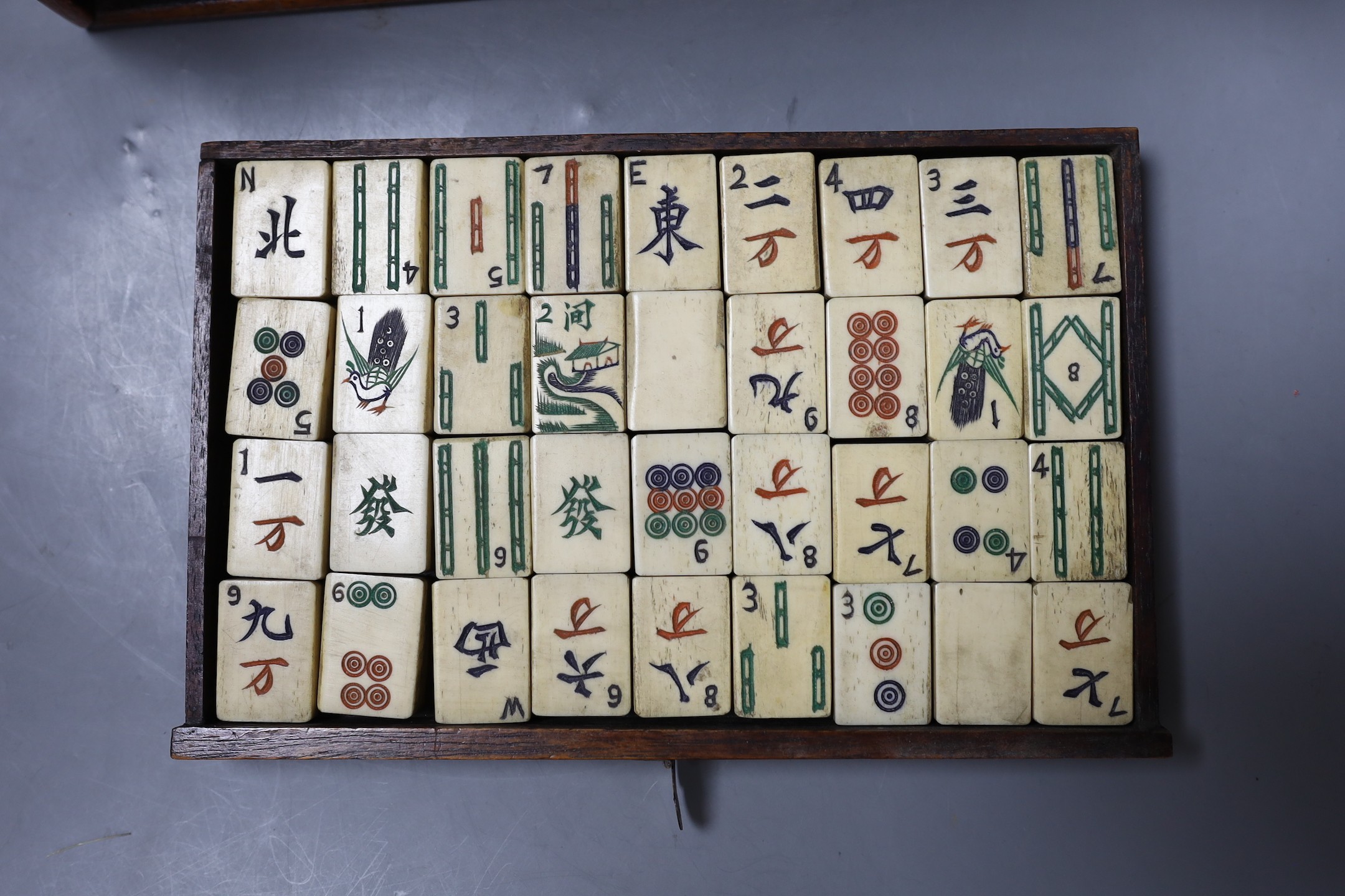 An early 20th century Chinese hardwood cased bone and bamboo mahjong set